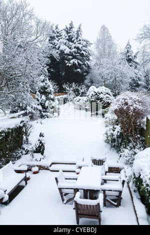 Jardin d'hiver de banlieue et meubles de patio recouvert de neige Banque D'Images