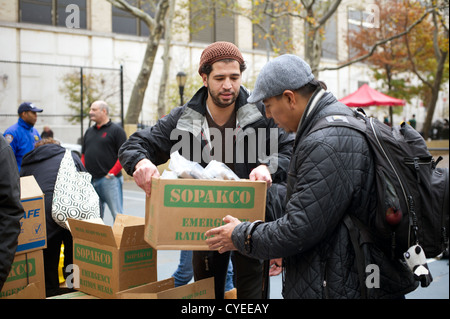 Prêt à manger des repas et des bouteilles d'eau sont distribués aux personnes dans le quartier de Chelsea à New York Banque D'Images