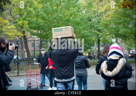 Prêt à manger des repas et des bouteilles d'eau sont distribués aux personnes dans le quartier de Chelsea à New York Banque D'Images