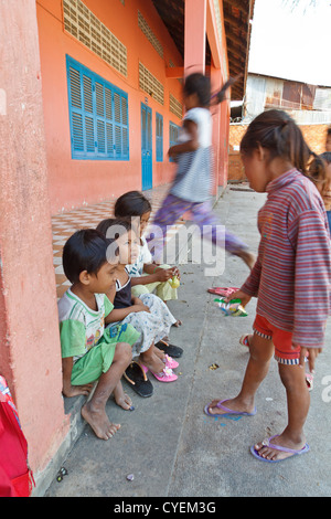 Les enfants jouant sur la cour d'une école près de l'ancienne décharge de Stung Meanchey à Phnom Penh, Cambodge Banque D'Images