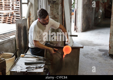 L'homme travaillant avec du verre en fusion pour créer le célèbre verre de Murano dans une fonderie de verre sur l'île de Murano, Venise, Italie Banque D'Images