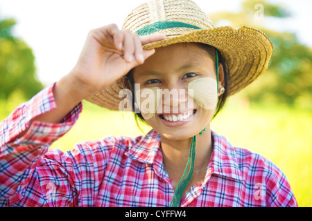 Portrait d'une jeune femme birmane avec thanaka face en poudre qui travaille dans le domaine Banque D'Images
