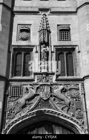 Le noir et blanc Detais au-dessus de la porte d'entrée avec les grandes portes du Christ's College, Université de Cambridge, Angleterre Banque D'Images