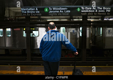 3 novembre 2012, New York, NY, US. L'homme à la mairie centrale de Brooklyn attend que Subway train pour Manhattan. Service de métro, entre Manhattan et Brooklyn reprend cinq jours après les inondations de l'Ouragan Sandy a paralysé les transports en commun de New York. Banque D'Images