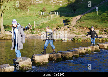 Les personnes qui traversent le plus célèbre des tremplins sur la rivière Dove Dovedale Derbyshire UK Banque D'Images