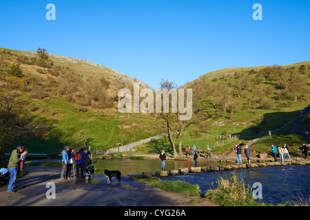 Les personnes qui traversent le plus célèbre des tremplins sur la rivière Dove Dovedale Derbyshire UK Banque D'Images