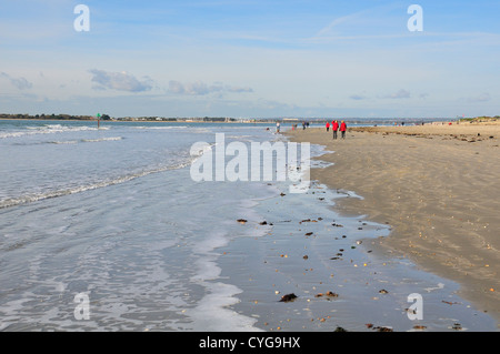 Scène de gens se promener le long de l'estran de West Wittering Beach au cours de l'automne Banque D'Images