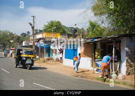 Vue horizontale des indiens locaux la collecte de l'eau douce à partir d'une borne fontaine au milieu d'une rue typique de Munnar, Inde. Banque D'Images