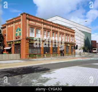 Les tuiles vernissées de la Croix d'or classé grade II pub à Cardiff contraste avec la plaine tuiles de l'édifice John Lewis Banque D'Images
