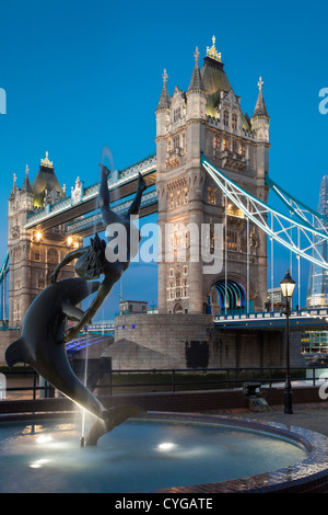 David Wynne's Girl avec un dauphin statue en dessous de la Tower Bridge, Londres, Angleterre, RU Banque D'Images