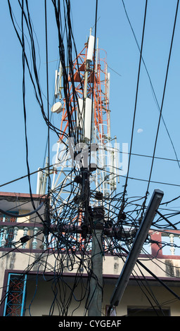 Pylône de l'électricité et les câbles à l'avant d'une tour de télécommunication dans une rue indienne. L'Andhra Pradesh, Inde Banque D'Images