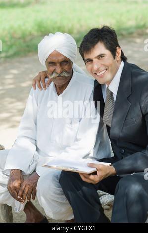 Conseiller financier assis avec un agriculteur et smiling Banque D'Images