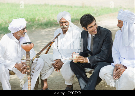 Discuter d'affaires avec trois agriculteurs Banque D'Images