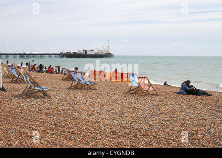 La jetée de Brighton vue de la plage de galets avec des personnes bénéficiant de mer et lifeguard en devoir. East Sussex. L'Angleterre Banque D'Images