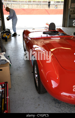 Un pilote se préparer dans un garage fosse avant une course. Banque D'Images