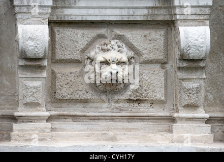 Tête de lion sculpté sur un fond de pierre rustiquée ornementer le mur extérieur du palais Rezzonico à Venise Banque D'Images