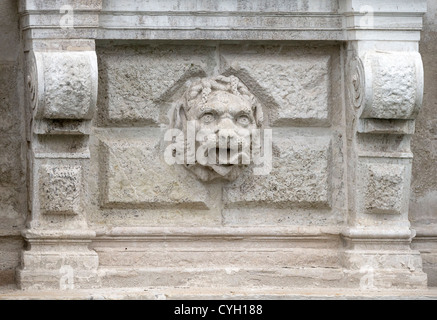 Tête de lion sculpté sur un fond de pierre rustiquée ornementer le mur extérieur du palais Rezzonico à Venise Banque D'Images
