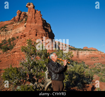 L'homme de l'Arizona joue flûte autochtone par Kachina Femme formation in Sedona, atteint par le sentier de randonnée Vista Banque D'Images