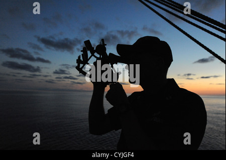 US Coast Guard Academy un candidat officier de navigation à l'aide de pratiques de l'étoile et d'un sextant, le soir pendant une session de formation le 13 septembre 2012 à bord de United States Coast Guard Barque Eagle dans l'océan Atlantique. Les candidats passent deux semaines à bord de l'aigle durant leur formation pour développer leur sens marin, le travail d'équipe et des compétences en leadership. Banque D'Images