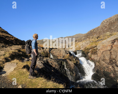 Walker par chute d'Afon mcg Llançà river par Watkin Path route vers Snowdon dans le parc national de Snowdonia, le Nord du Pays de Galles, Royaume-Uni, Angleterre Banque D'Images