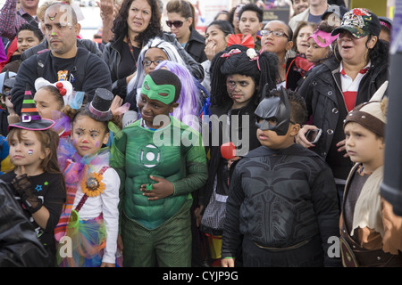 Défilé d'Halloween de Coney Island à Brooklyn, New York. Les enfants en costume d'être amusé et surpris par une épée avaleuse. Banque D'Images