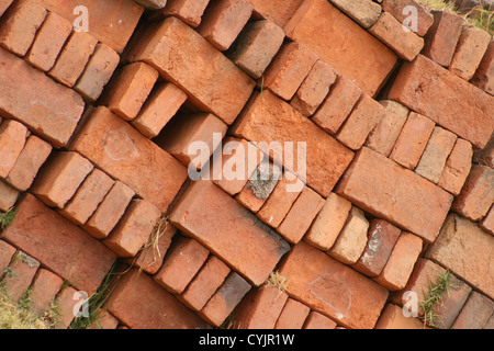 Rouge et Marron à la main des briques d'adobe sont empilés dans un motif abstrait sur un chantier de construction à Cotacachi (Équateur) Banque D'Images