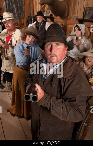 Expéditif flingueur avec fusil de chasse dans des vieux western saloon Banque D'Images