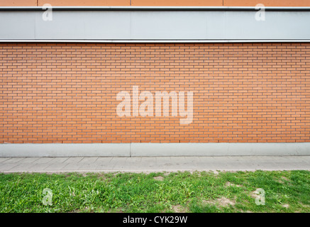 Mur de brique vide et la masse de l'herbe verte. Banque D'Images