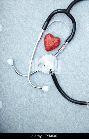 Stéthoscope médical et le cœur sur un fond texturé bleu Banque D'Images