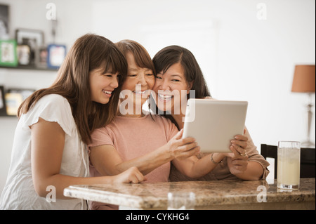 Grand-mère, mère et fille using digital tablet Banque D'Images