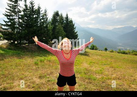 Femme sautant de joie sur la colline Banque D'Images