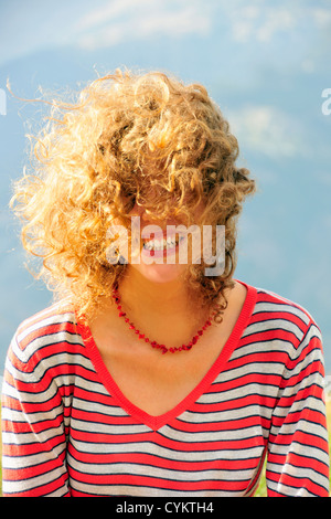 Smiling woman's hair blowing in wind Banque D'Images