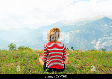 Woman meditating on rural hilltop Banque D'Images