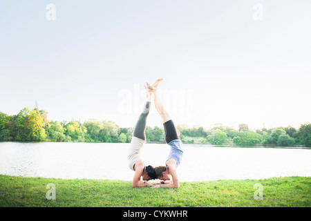 Couple practicing yoga par l'eau Banque D'Images