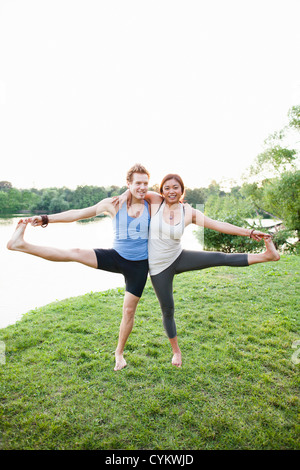 Couple practicing yoga par l'eau Banque D'Images