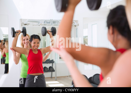 Femme travaillant avec formateur dans une salle de sport Banque D'Images