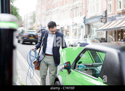 Voiture électrique de charge l'homme dans la rue Banque D'Images