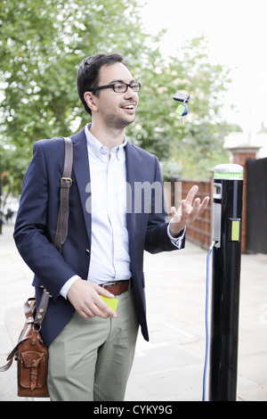 Voiture électrique de charge l'homme dans la rue Banque D'Images