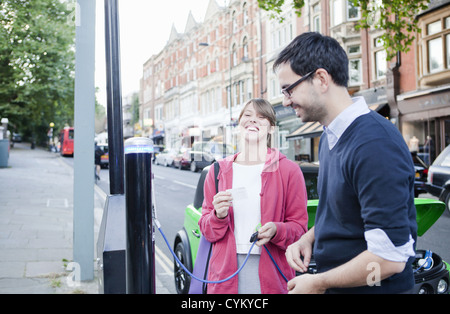 Voiture électrique de charge Couple on street Banque D'Images