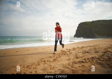 Woman running on beach Banque D'Images