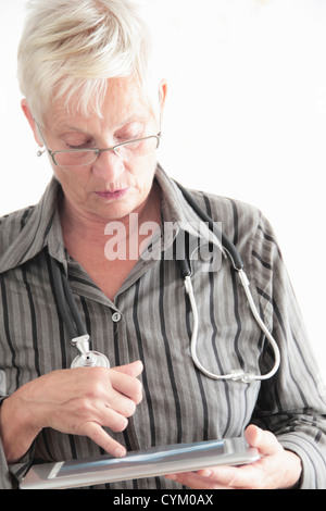 Doctor using tablet computer in office Banque D'Images