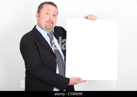 Man in suit holding white sign Banque D'Images