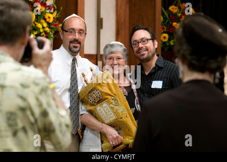 Femme juive, 67, pose pour photos holding Torah après sa Bat Mitzvah cérémonie durant son service au Sabbat synagogue Banque D'Images