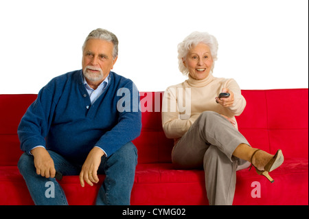 Couple de personnes âgées sur le canapé avec la télécommande du téléviseur Banque D'Images