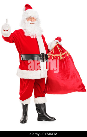 Portrait d'un Père Noël tenant un sac plein de cadeaux et de donner un pouce vers le haut isolé sur fond blanc Banque D'Images