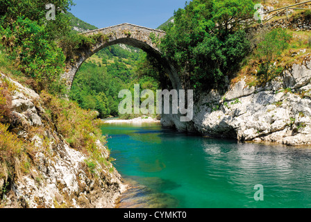 L'Espagne, Asturies : Roman pont de pierre sur la rivière de montagne s'occupe dans le Parc National Picos de Europa Banque D'Images