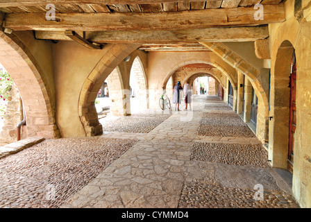 France, Midi-Pyrénées : Native women chatting sous les arcades de la place aux Arcades dans Bastide Sauveterre de Rouergue Banque D'Images