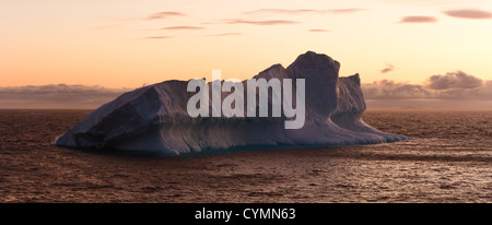 Gros iceberg flottant dans la mer au crépuscule. Encadrée horizontalement shot. Banque D'Images