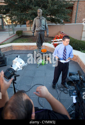 Journaliste de télévision n'en rapport d'une statue d'avant le légendaire entraîneur de football de l'Université du Texas Darrell royal après la mort de Royal Banque D'Images