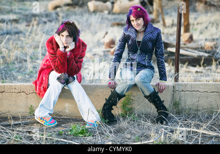 Deux Mode Filles assis sur un mur de ciment Banque D'Images